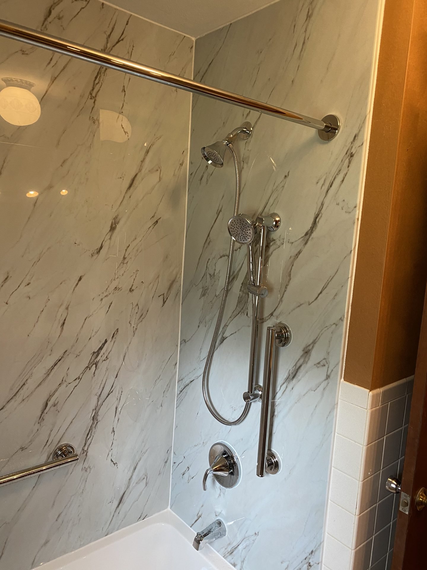 Marble shower wall with handheld and fixed shower heads
