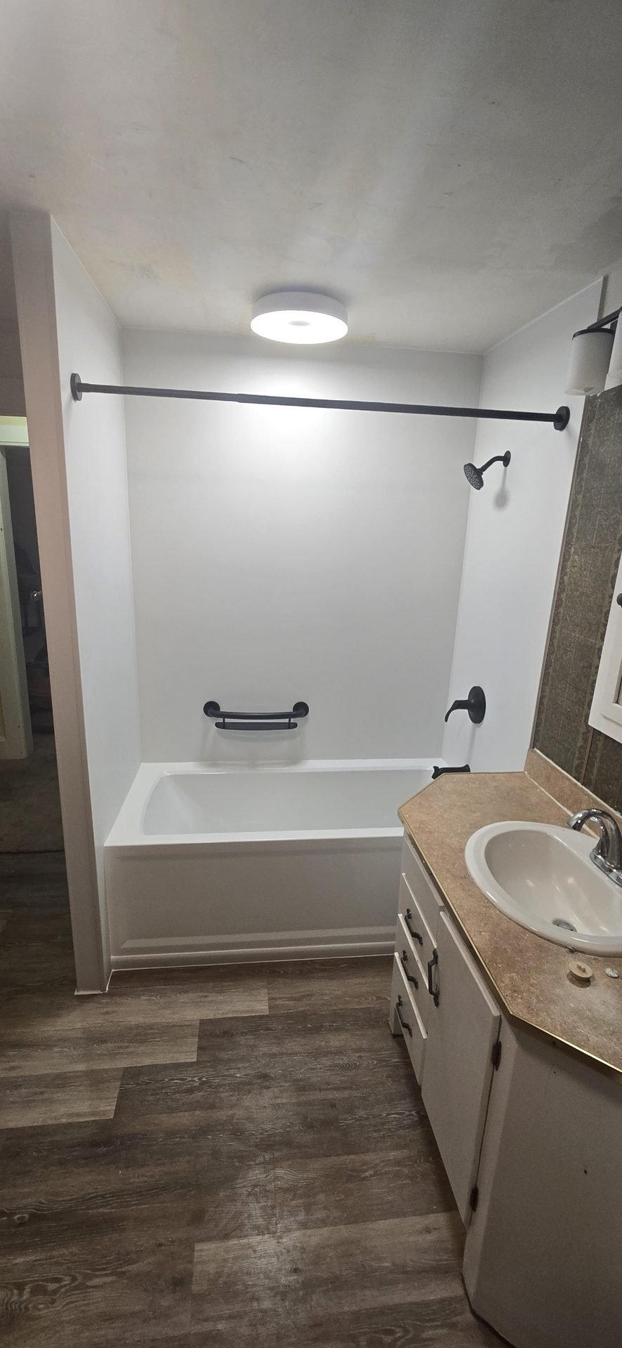 White tub-to-shower conversion with bronze fixtures